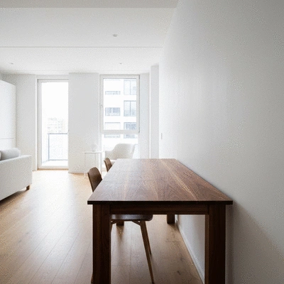 Sleek rectangular dining table set against a wall in a narrow modern apartment